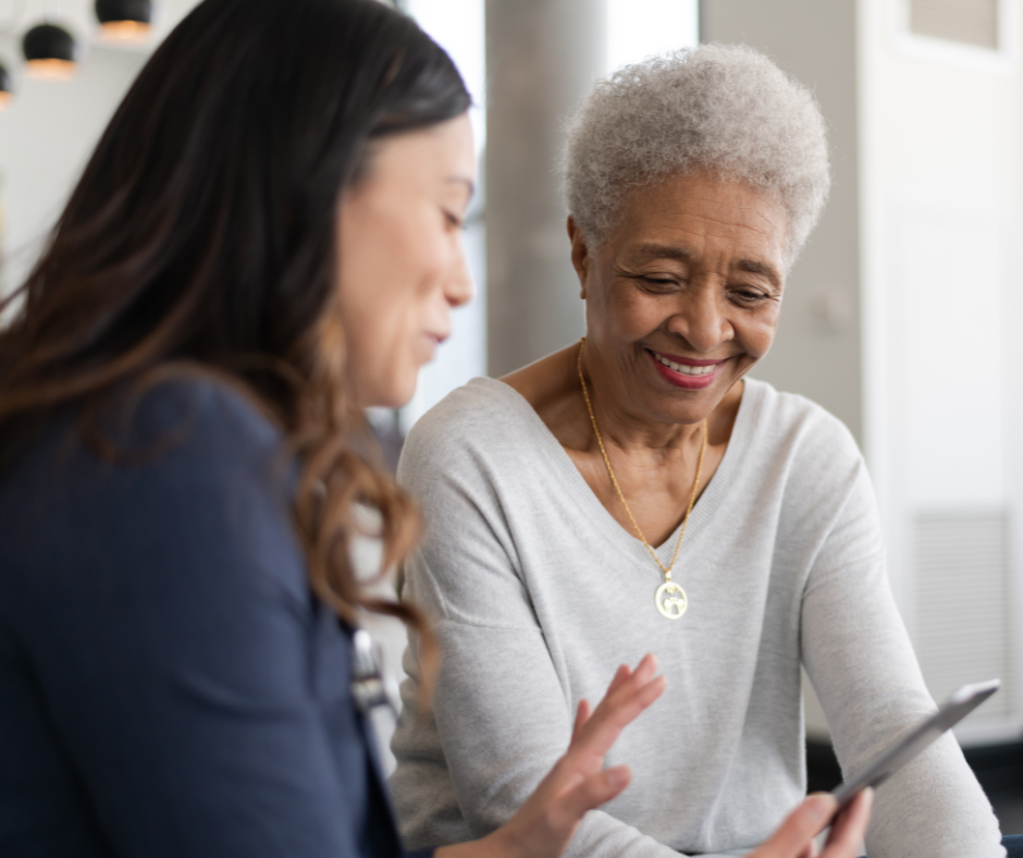 image showing a healthcare worker helping an elderly patient access telehealth services.